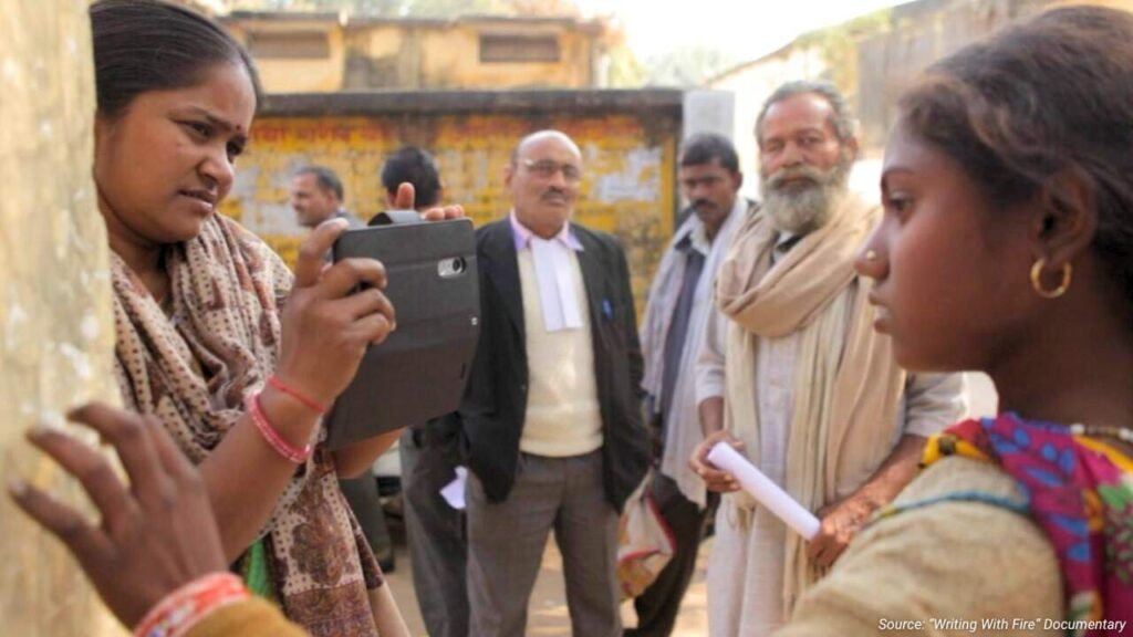 An Indian woman using a mobile phone to record an interview, showcasing the rise of digital and citizen journalism.