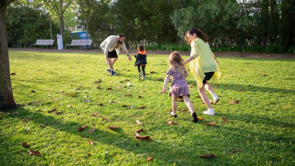 A family playing outdoors in a park, illustrating the importance of outdoor activities to combat Myopia.
