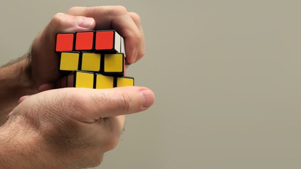 Hands solving a Rubik’s cube to symbolize improving fluid intelligence.